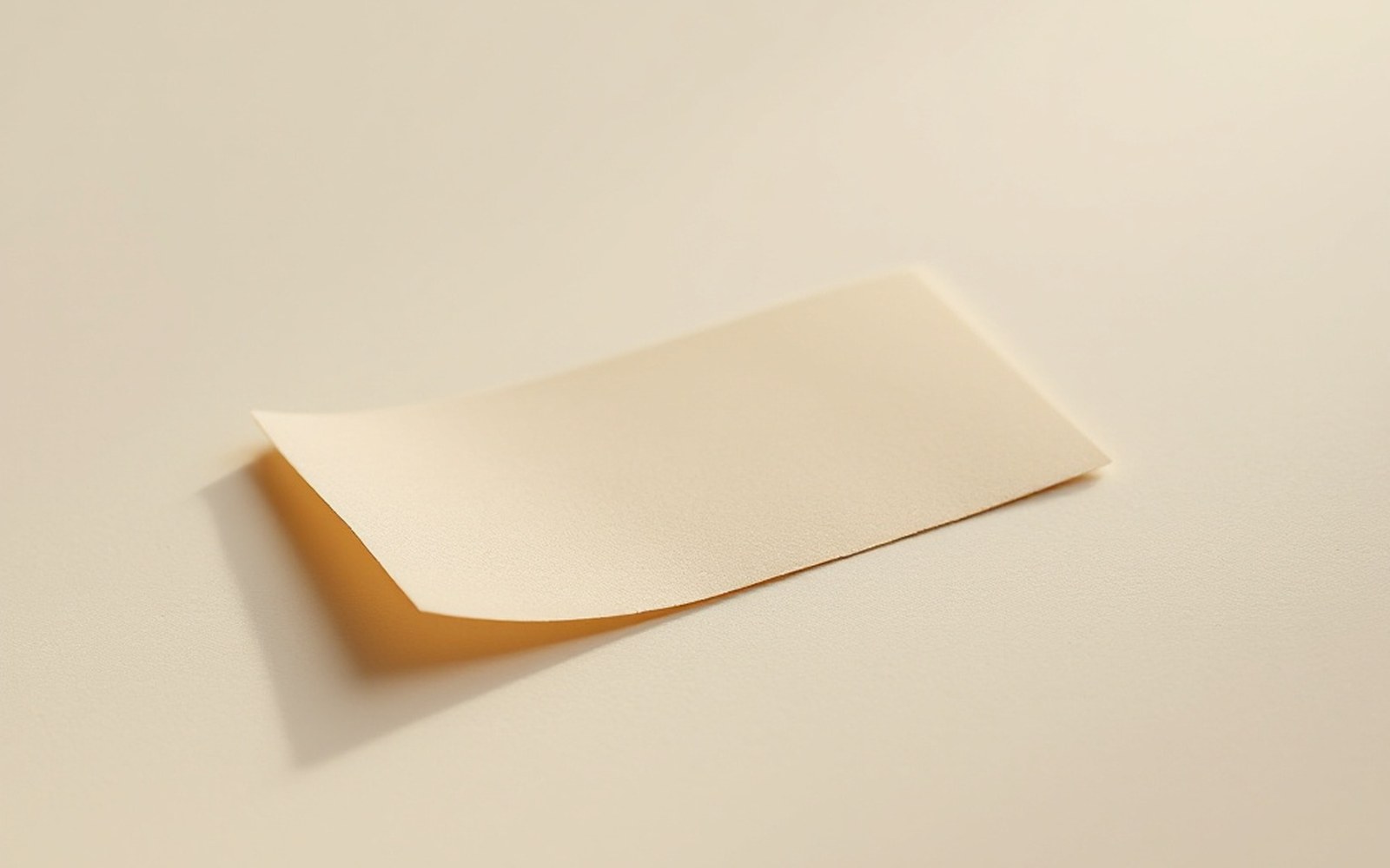 A small printed paper certification label lying flat on a plain pale surface, macro, even light, no bottle and no writing legible